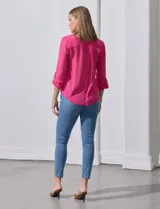 Blusa blanca de gasa marca Zac & Rachel, con cuello a la base, escote en V, abertura central con botones, bolsillo aplicado en el pecho y mangas largas regulables con presilla y botón. Tiene terminación opcional de nudo en el ruedo.