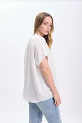 Camiseta blanca de manga corta con dobladillo en las mangas y cuello redondo.