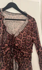 Blusa de microtul con estampado animal print en tonos marrones y negros, con escote en V y mangas largas.