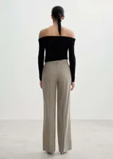 Pantalón de vestir color beige, de corte wide leg, tiro medio y pinzas frontales.