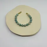 Pulsera elástica con cuentas de amazonita color celeste y cierre de acero hipoalergénico con baño de oro.