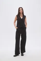 Pantalón ancho de poliéster negro con rayas verticales blancas, de calce medio y bolsillos laterales.