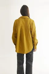 Camisa color beige de corte clásico con cuello, mangas largas y bolsillo frontal.