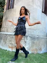 Minifalda negra de lentejuelas con flecos en el ruedo y tirantes finos con strass.