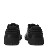 Zapatilla urbana Caterpillar Hex +, color negro, con exterior de cuero napa texturizado y detalles en amarillo. Presenta cordones negros y una suela robusta de goma con patrón hexagonal.