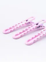 Pack de tres pinzas para el pelo color rosa con diseño ondulado.