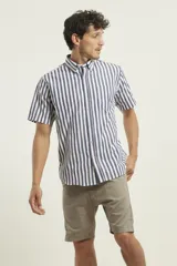 Camisa de manga corta a rayas verticales azules y blancas, con cuello abotonado y bolsillo en el pecho.