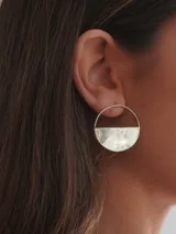 Par de aros dorados con forma circular, divididos horizontalmente: la mitad superior es un aro fino y la mitad inferior es un semicírculo sólido.