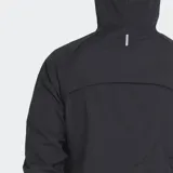 Cortavientos deportivo Le Coq Sportif, color negro, con capucha y cierre frontal. Presenta el logo del gallo en amarillo neón en el pecho izquierdo. El tejido es ligero y arrugado, típico de cortavientos.