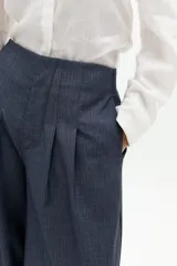 Pantalón culotte azul piedra, de tiro alto, con pinzas en la cintura y piernas anchas. Presenta sutiles rayas bordó y bolsillos laterales.