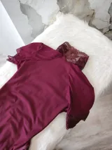 Body entallado de lycra color bordo con detalles en microtul y encaje. Con cuello alto y espalda descubierta.