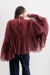 Camisa color marrón con cuello mao, mangas largas abullonadas y detalle de volados en el frente.