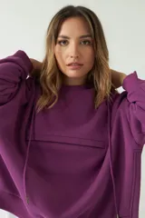 Buzo verde oscuro de corte recto y amplio, con capucha con cordones regulables y bolsillo frontal con cierre.