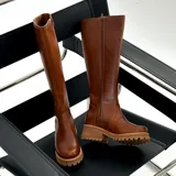 Bota de caña alta color marrón, confeccionada en cuero vacuno. Tiene suela de goma sport artesanal, cierre YKK del lado interno y horma de punta redonda.