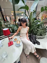 Conjunto de top y pollera color crema con ribetes negros. El top es musculosa con cuello redondo y la pollera es larga con estampado abstracto.