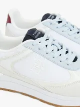 Zapatillas Tommy Hilfiger blancas con detalles en azul, rojo y suela color caramelo.