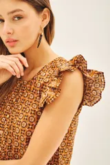 Camisa color marrón con estampado geométrico, escote redondo, mangas cortas con volados estampados y tajos laterales.