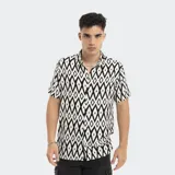 Camisa de manga corta con estampado geométrico en blanco y negro, cuello clásico y cierre frontal con botones.