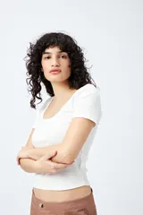 Remera color beige de punto acanalado, con escote redondo amplio y mangas cortas.