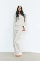 Sweater color crema de tejido suave, con cuello redondo en rib y mangas largas sin costuras.