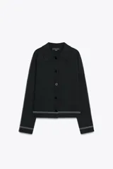 Chaqueta corta negra de punto con cuello solapa, manga larga y cierre frontal con botones.