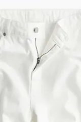 Pantalón de jean blanco de tiro alto, corte amplio en la pierna y cinco bolsillos.