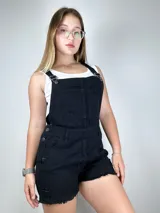 Enterito de mezclilla negro con roturas, tirantes ajustables y bolsillo frontal.