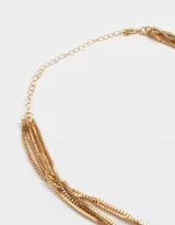 Collar dorado de tres cadenas finas con eslabones cuadrados y cierre de mosquetón.