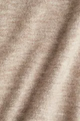 Remera de punto color beige melange, con cuello redondo, mangas cortas amplias y puños y bajo acanalados.