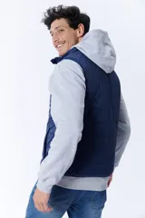Chaleco acolchado azul marino con cierre frontal y cuello alto. Reversible, con interior en tono celeste. Sin mangas.