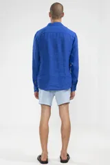 Camisa azul de lino con botones de coco y corte recto.