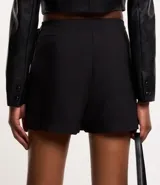 Short pollera corto de crepé negro con detalle satinado asimétrico y lazo lateral.