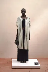 Vestido camisero largo con estampado de rayas verticales negras y crudas, corte recto, manga larga con puños y bolsillo en el pecho.