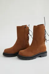 Botas de caña media de gamuza color verde militar, con acordonado en la parte posterior y suela robusta.