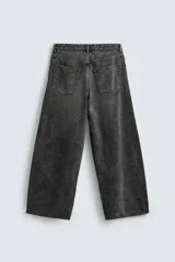 Pantalón de jeans de algodón, corte baggy fit, tiro medio, con efecto lavado en tonos grises y verdes. Presenta cinco bolsillos y cierre frontal con cremallera y botón.