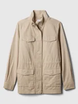Campera de lona suave, con manga larga, cuello alto y cierre frontal con broche y cremallera, además de bolsillos de parche en el pecho y en el bajo.