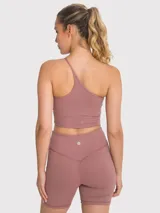Crop top deportivo negro con sujetador integrado de un hombro y almohadillas removibles.