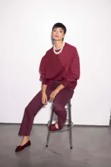 Buzo bordó de jogging con friza, corte holgado y mangas balloon. Presenta un estampado bordado con hilo de algodón y lurex en el frente.