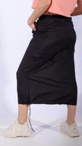 Falda midi negra de nylon con cintura elastizada ajustable con cordón, bolsillos laterales y detalle de frunces.
