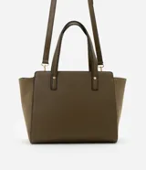 Cartera mediana color beige con paneles laterales de gamuza, doble asa de mano y correa larga desmontable.