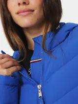 Campera acolchada azul eléctrico con cierre frontal, cuello alto con capucha ajustable y bolsillos laterales.