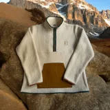 Buzo de fleece color natural con cierre en el cuello y bolsillo frontal, diseñado para mayor comodidad.