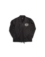 Campera negra tipo coach con cierre de botones a presión, bolsillos laterales y logo de la marca Deus Ex Machina estampado en el pecho.