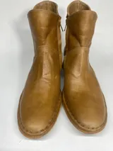 Bota de cuero color marrón claro, de caña corta y taco bajo.