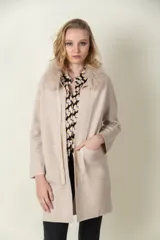 Saco largo color beige con cuello de piel sintética desmontable, solapas con muesca, bolsillos laterales y corte recto.