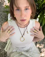 Collar con dije circular irregular de alpaca y plata 925, con hilo de algodón natural.