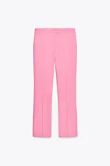 Pantalón color arena de tiro alto con bolsillos delanteros y corte acampanado. Cierre frontal con cremallera y gancho metálico.