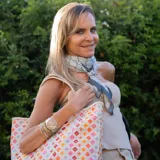 Bolso tipo tote bag con estampado geométrico multicolor y asas de cuero sintético color crema.