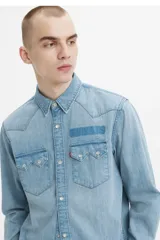 Camisa de denim celeste de corte recto, con mangas largas, cuello clásico, cierre con botones a presión, dos bolsillos con solapa abotonada en el pecho y canesú en la espalda.