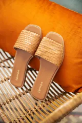 Sandalias bajas color marrón claro con capellada trenzada y plantilla con logo de la marca.